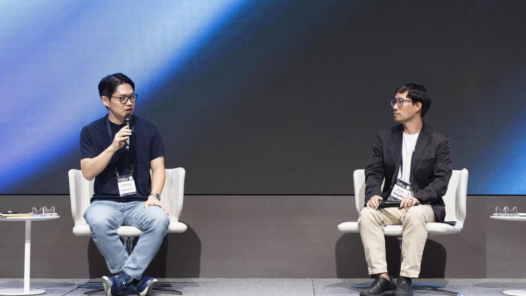 SK Networks President and Chief Operating Officer Choi Sung-hwan, left, speaks to Upstage CEO Sung Kim during SK Networks AI WAVE 2025 at Grand Walkerhill Seoul, Wednesday. Courtesy of SK Networks